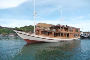 a large wooden boat sitting in the water at Phinisi Private trip Komodo Island in Komodo Labuan Bajo Airport