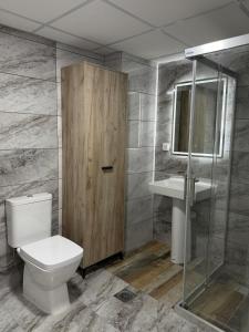 a bathroom with a toilet and a sink and a shower at Skopje Riverfront Modern Apartment in Skopje +3 photos