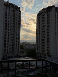 a view of two tall buildings from a balcony at Skopje Riverfront Modern Apartment in Skopje