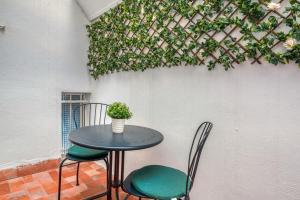a table with two chairs and a plant on a wall at CaTere Estancia Bocairent in Bocairent