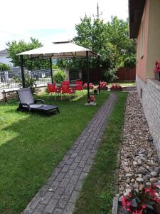 a garden with a bench and an umbrella at Magdaléna Vendégház in Esztergom +18 photos
