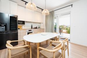 a kitchen with a white table and chairs at Residence Giardino in Ugljan