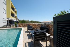 a patio with chairs and a swimming pool at Residence Giardino in Ugljan