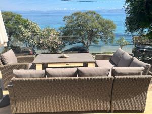 a group of wicker chairs and a table on a patio at Boukari Blu Studio Boukari Beach in Boukari