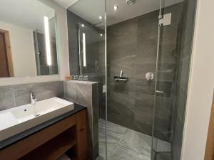 a bathroom with a sink and a glass shower at Zugspitzblick - pur! in Lermoos