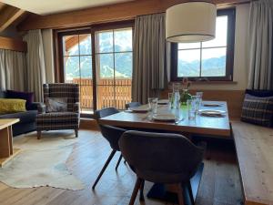 a living room with a dining room table with chairs at Zugspitzblick - pur! in Lermoos