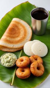 a plate of food with bread and onion rings and dips at Hotel Prithvi Studio - RDC And Santosh Hospital in Ghaziabad +16 photos
