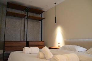 a bedroom with two beds with white sheets at Dream Suites - Lake View Residences in Tirana