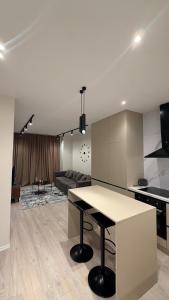 a kitchen and living room with a table and a couch at Dream Suites - Lake View Residences in Tirana