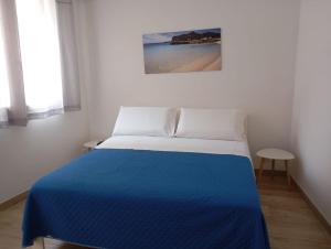 a bedroom with a bed with a blue blanket at Casa dei mulini in Favignana +17 photos
