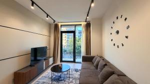a living room with a couch and a television at Dream Suites - Lake View Residences in Tirana