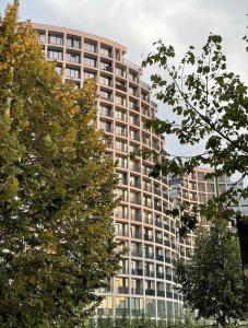 a tall building with trees in front of it at Dream Suites - Lake View Residences in Tirana