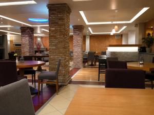 ein Restaurant mit Tischen und Stühlen und einer Backsteinmauer in der Unterkunft Souris Hotel in Rovies