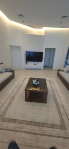 a living room with a coffee table and a flat screen tv at Paradise in Al Khīrān +10 photos