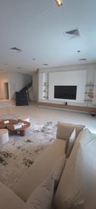 a living room with a couch and a flat screen tv at Paradise in Al Khīrān