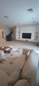 a living room with a couch and a flat screen tv at Paradise in Al Khīrān