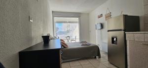 a small room with a bed and a refrigerator at Le paradis du Port Cozy studio near port and beaches in Cap dAgde in Cap d'Agde