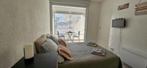 a bedroom with a bed with a tv and a window at Le paradis du Port Cozy studio near port and beaches in Cap dAgde in Cap d'Agde