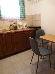 a kitchen with wooden cabinets and a table and chairs at Magdaléna Vendégház in Esztergom