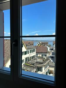 a view of a city from a window at Stadtloft Suites Richterswil in Richterswil