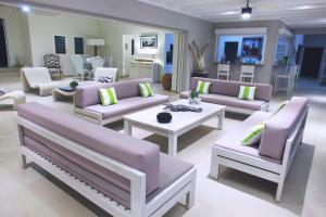ein großes Wohnzimmer mit Sofas und einem Tisch in der Unterkunft Seafacing Villas Apartments Rentals in Les Terres Basses