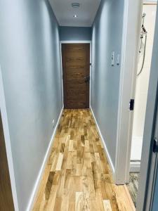 a hallway with a door and a wooden floor at Whiteleys Cottages 2 bedroom in Renton