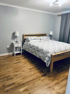 a bedroom with a bed and a wooden floor at Whiteleys Cottages 2 bedroom in Renton
