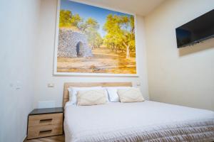 a bedroom with a bed and a painting on the wall at Salento Ada's House in Melendugno