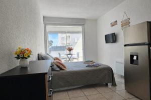 a small room with a bed and a refrigerator at Le paradis du Port Cozy studio near port and beaches in Cap dAgde in Cap d'Agde