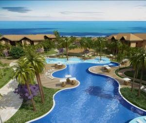 an aerial view of a resort pool with palm trees at VG Cumbuco J&Y in Caucaia