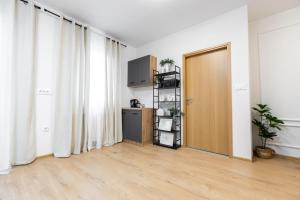 an empty living room with a door and curtains at Apartmani Triluna in Drškovci +26 photos
