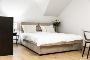 a bedroom with a large bed with white sheets and pillows at Apartmani Triluna in Drškovci