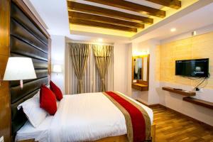a bedroom with a large bed and a flat screen tv at Beautiful Kathmandu Swimming pool Hotel in Kathmandu