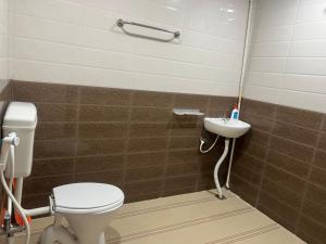 a bathroom with a toilet and a sink at Aerodon resort in Chennai