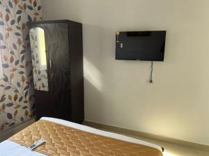 a bedroom with a bed and a flat screen tv at Aerodon resort in Chennai
