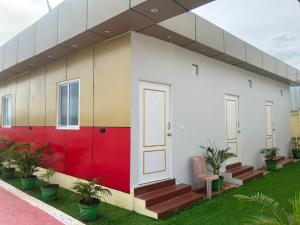 a building with a red and white facade with plants at Aerodon resort in Chennai