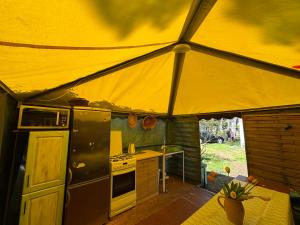 a kitchen in a tent with a stove top oven at Dębowy zakątek camping in Pobierowo