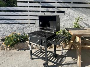 a barbecue grill with a laptop computer on it next to a table at Seascape Village - Spacious 3-Bed Apartment with Private Garden and Parking in Kalithies +23 photos