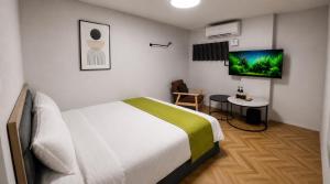 a hotel room with a bed and a tv at 礁溪希沐湯泉民宿 2026年7月全新面貌登場 價格優惠中 in Jiaoxi +15 photos