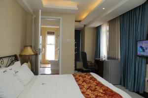 a hotel room with a bed and a television at Grand Plaza Hotel in Kampala +55 photos