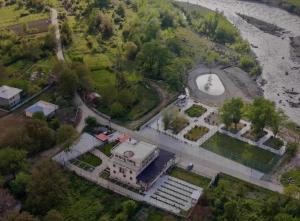 an aerial view of a mansion next to a river at Khidikari Hotel in Ambrolauri