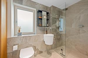 a bathroom with a toilet and a glass shower at Appartment SPATZENNEST in Bietigheim-Bissingen +9 photos