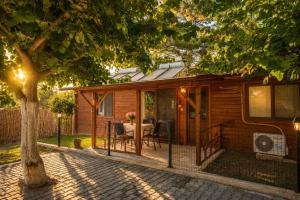 a wooden cabin with a table and chairs in a yard at Cirali Camping in Cıralı