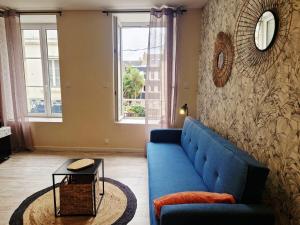 a living room with a blue couch and a table at Le Key Largo in Cherbourg en Cotentin