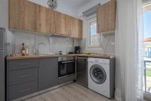 a kitchen with a washing machine and a dishwasher at SLV Dionysos Apartment in Ofrínion +13 photos