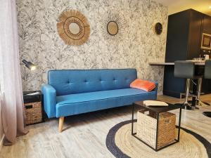 a blue couch in a living room with a wall at Le Key Largo in Cherbourg en Cotentin +24 photos
