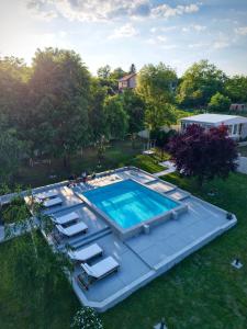 an overhead view of a swimming pool with loungers and a house at YAMM Pool House in Mali Požarevac