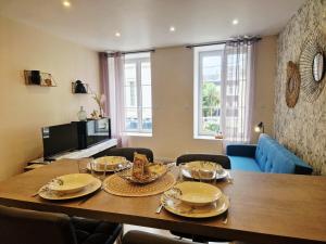 a dining room with a table and a blue couch at Le Key Largo in Cherbourg en Cotentin