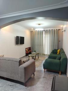 a living room with two couches and a tv at E- Gem in Gulu