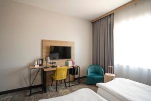 a hotel room with a desk and a tv at ibis styles Grudziadz in Grudziądz +158 photos